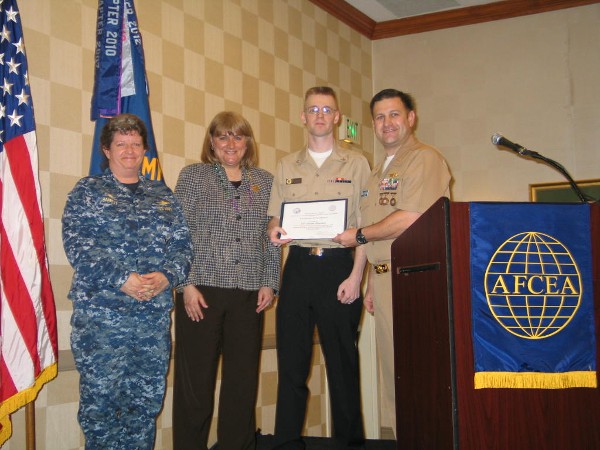Duvall presents the February Military Cyber Professional Award to Petty Officer 3rd Class Justin Blucher, USN (2nd from l), Naval Computer Telecommunications Area Master Station, Atlantic (NCTAMS LANT), while Capt. Danelle Barrett, USN, commanding officer, NCTAMS LANT, and Lt. Cmdr. Dave Pereira, USN, chapter vice president for military affairs, stand witness.